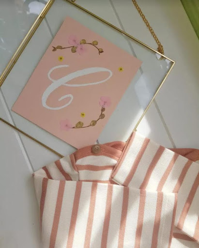 Frame with C letter monogram flower art on pink background with a pink and white shirt