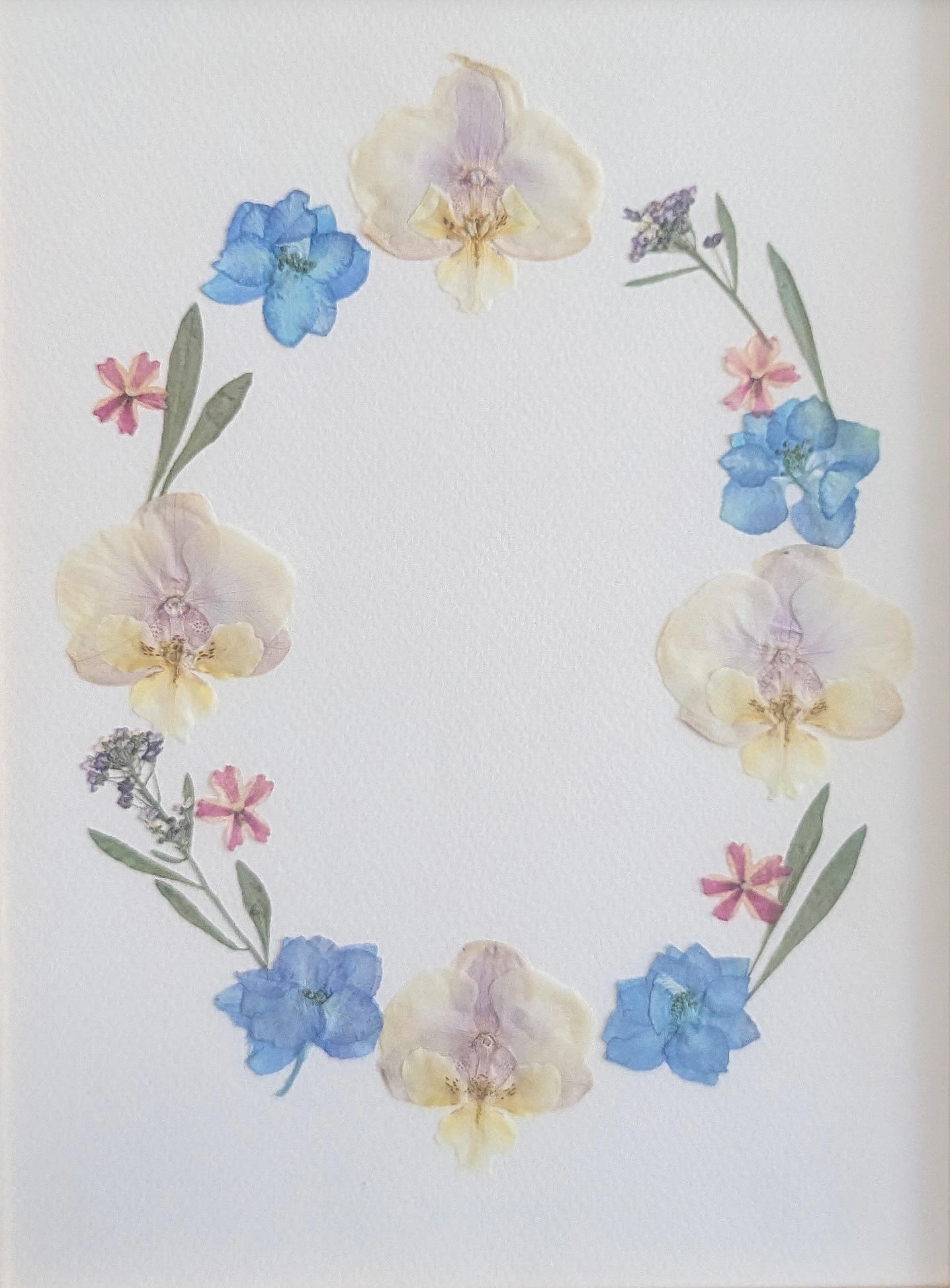 Crown of blue, pink and white flowers on a pastel green background